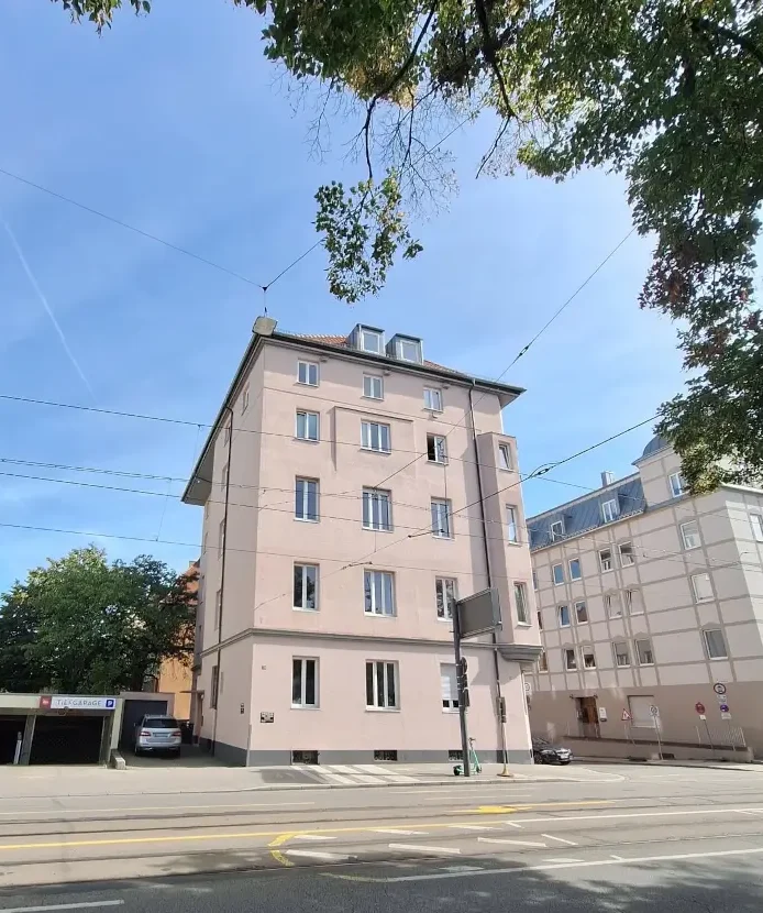 Hermanstraße 29 Augsburg, Zahnarzt Augsburg Innenstadt Rosa Gebäudes in der Hermanstraße 29, Augsburg mit Parkplatz, in dem die Praxis Semmler, Zahnarzt Augsburg Innenstadt ist.